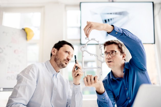 Two men viewing an extruded aluminium profile