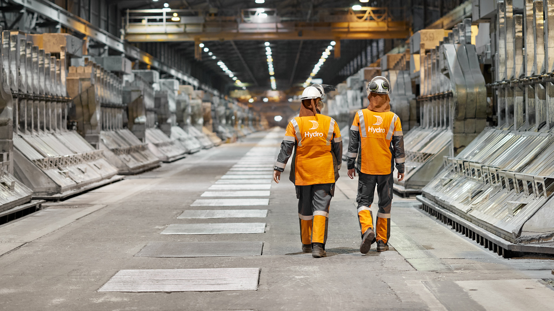 men in safety vests in a factory