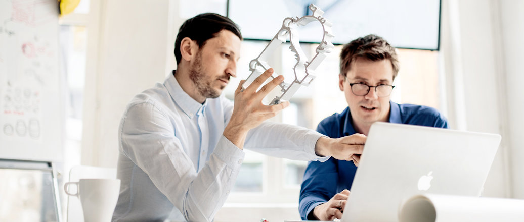 a man showing a man something on the computer