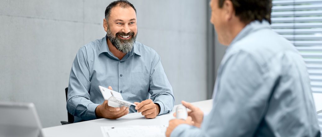 a man showing a man something on the paper