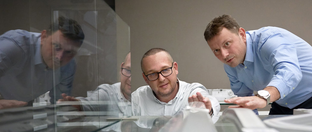 a group of men looking at a computer screen