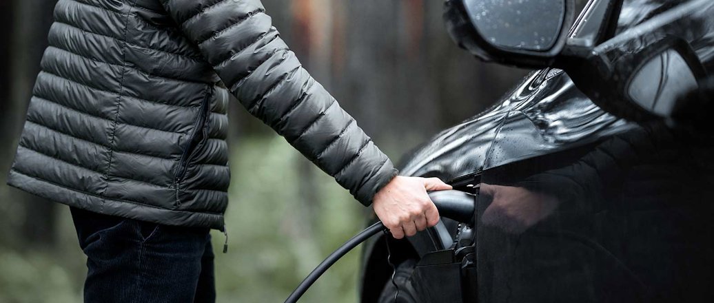 Man charging electric vehicle