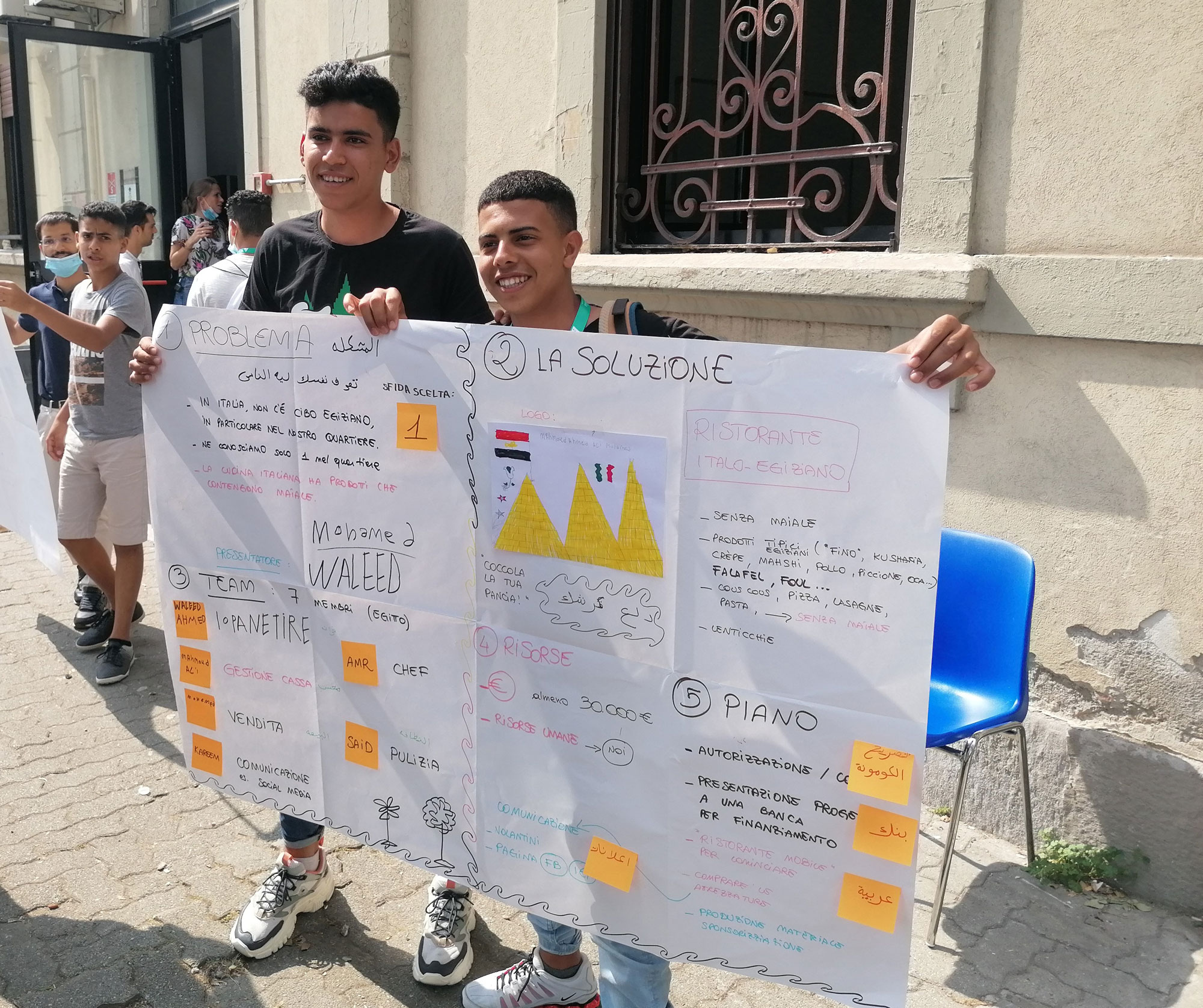 a couple of men holding up a large poster