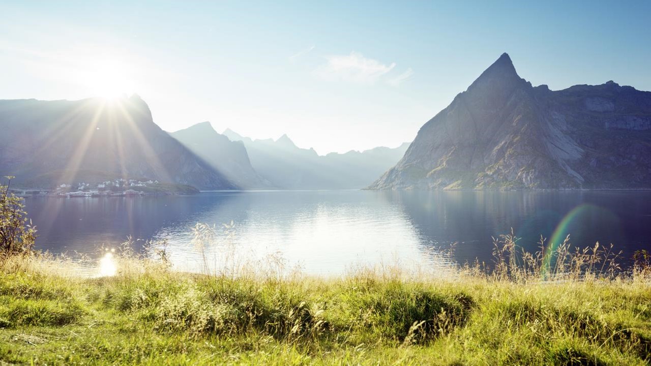 a body of water with mountains in the background with Milford Sound in the background