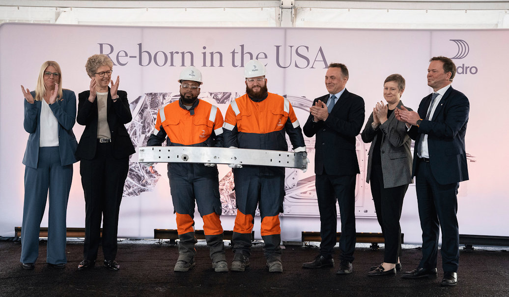 The state-of-the-art aluminium recycling plant was officially opened on Thursday, November 16. From left: Emilie LaGrow, Village Manager Cassopolis, Hilde Merete Aasheim, President & CEO Hydro, Dre Kiser, Production Operator, Tyler First, Production Operator, Tore Onshuus Sandvik, State Secretary Labour Party, Jen Nelson, Chief Operating Officer, Michigan Economic Development Corporation and Eivind Kallevik, Executive Vice President Hydro Aluminium Metal. Dre and Tyler, who have known each other since first grade, are holding a bumper beam for cars made with recycled aluminium.