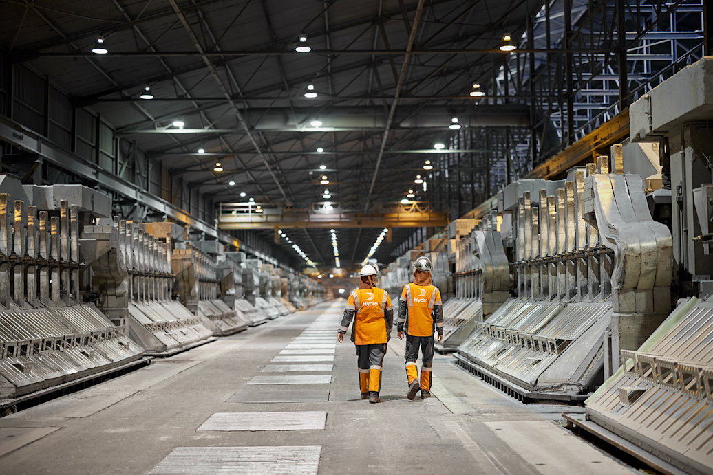 two people in safety vests in a factory
