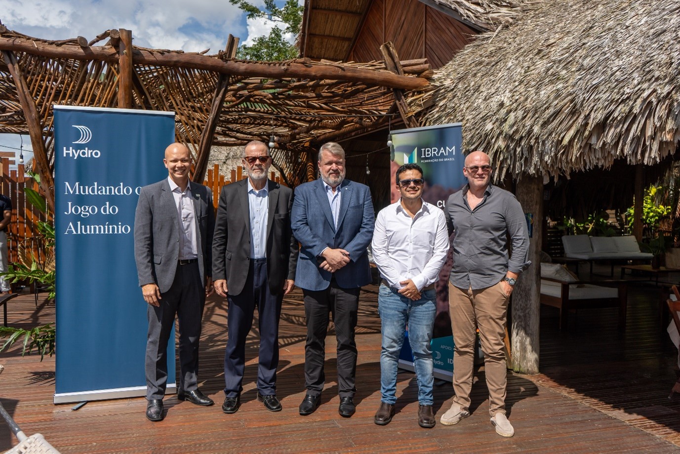 a group of men standing in front of a sign