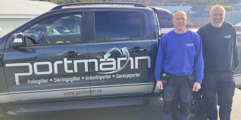 two men standing next to a truck