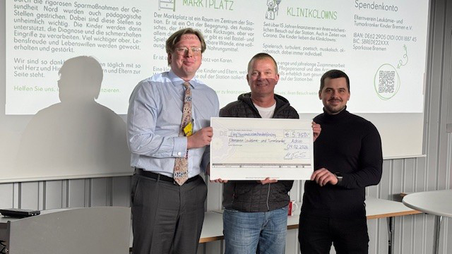 a group of men holding a check