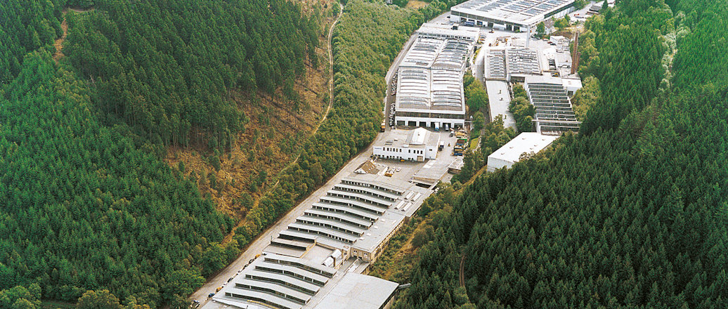 a large building with a large roof surrounded by trees