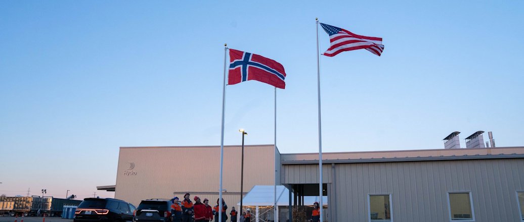 A Norwegian and a US flag in front of a Hydro plant