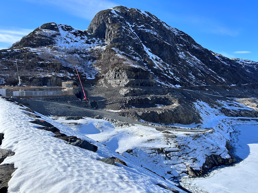 a mountain with snow and a building