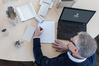 a person sitting at a desk with a laptop and papers